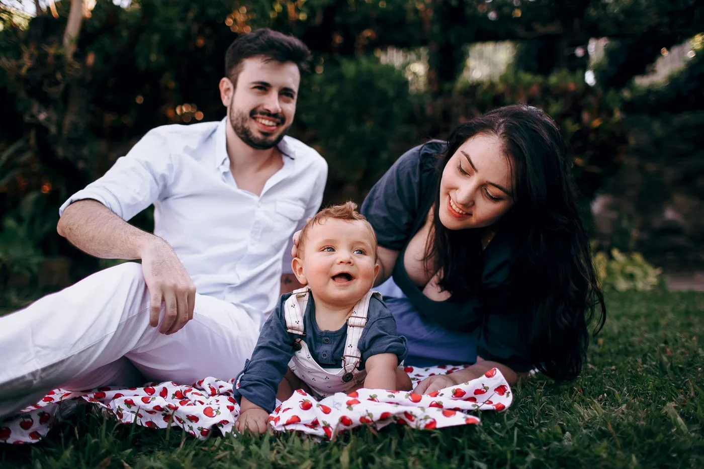 Parents spending time with their young child on grass