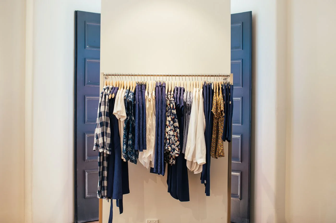 A row of clothing on hangers in an open wardrobe