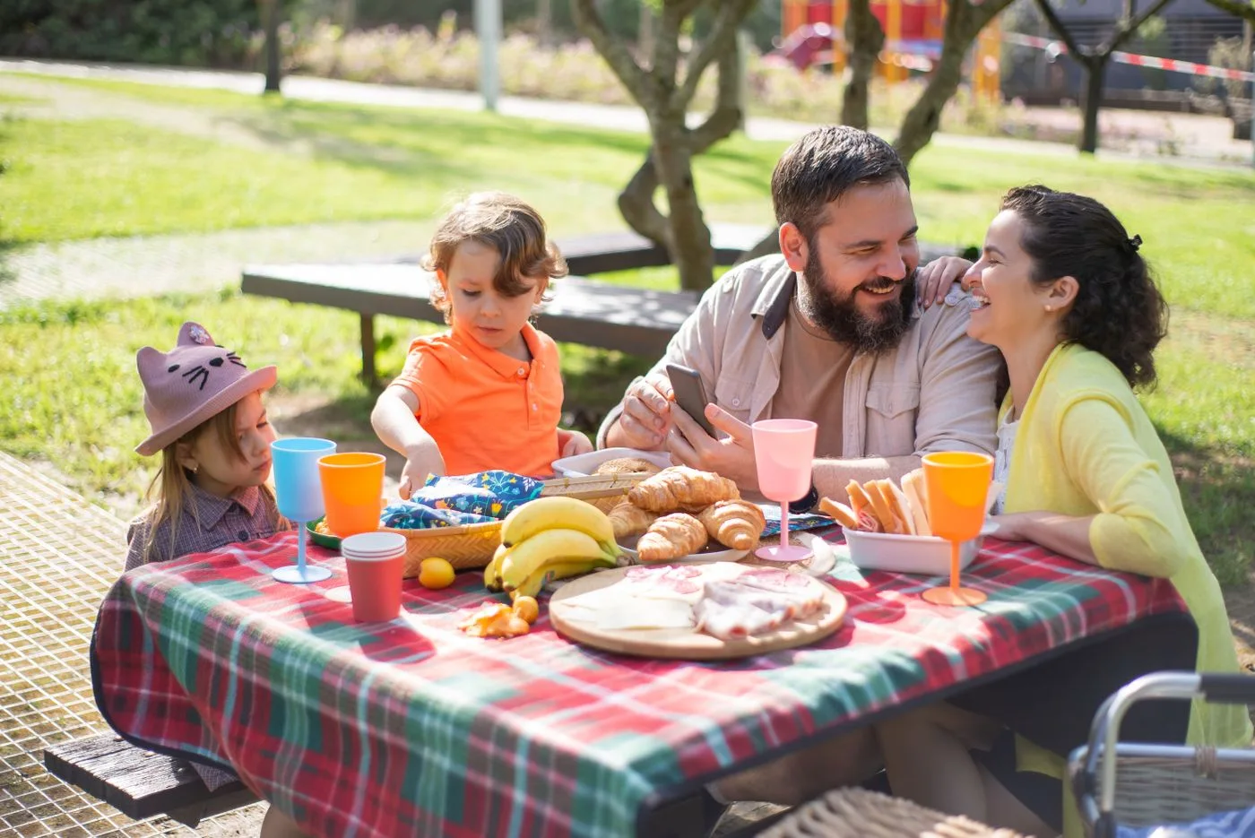 Adults and children gathered around an outdoor picnic table